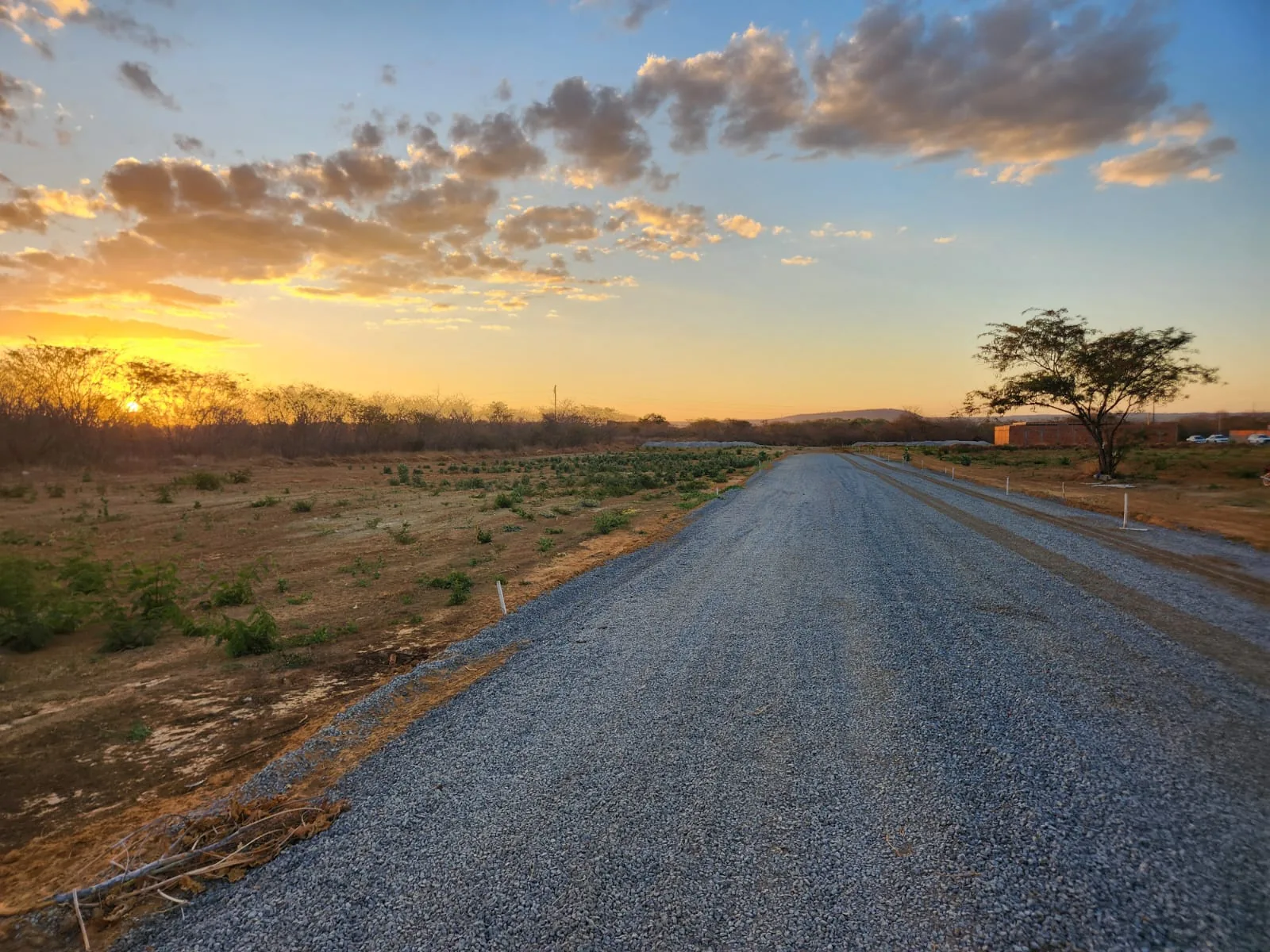 Rua do loteamento com pôr do sol